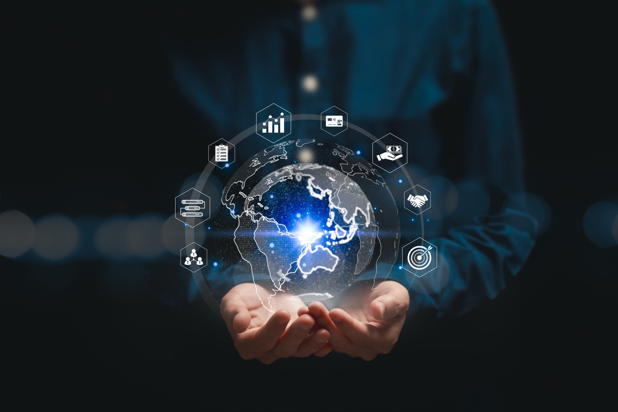 Hands holding a digital globe with various media and analytics icons.